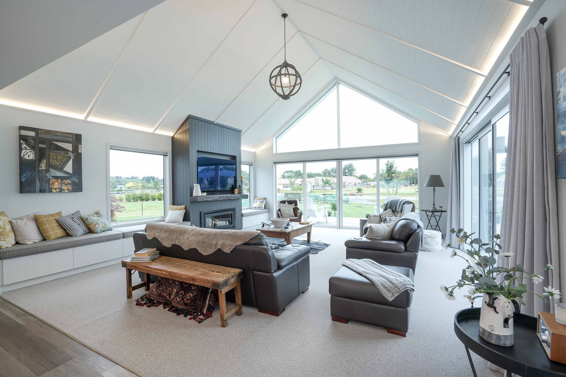 Living area of the home that has made full use of the space by using high ceilings and floor to ceiling windows.