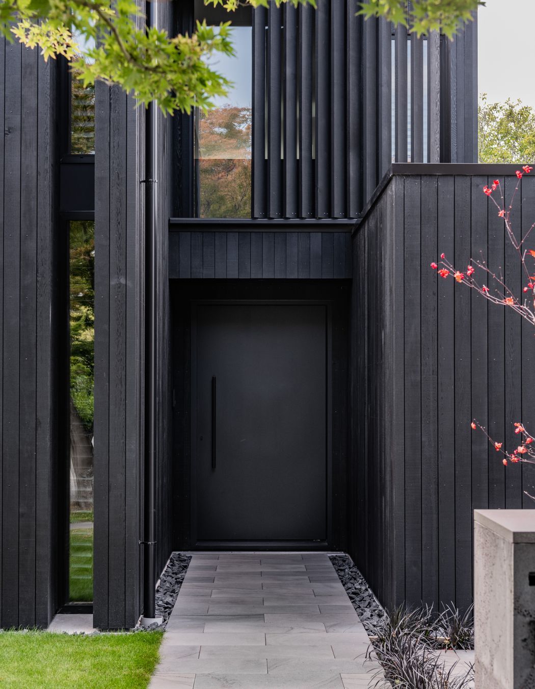 The front door blends with the rest of the exterior materiality.