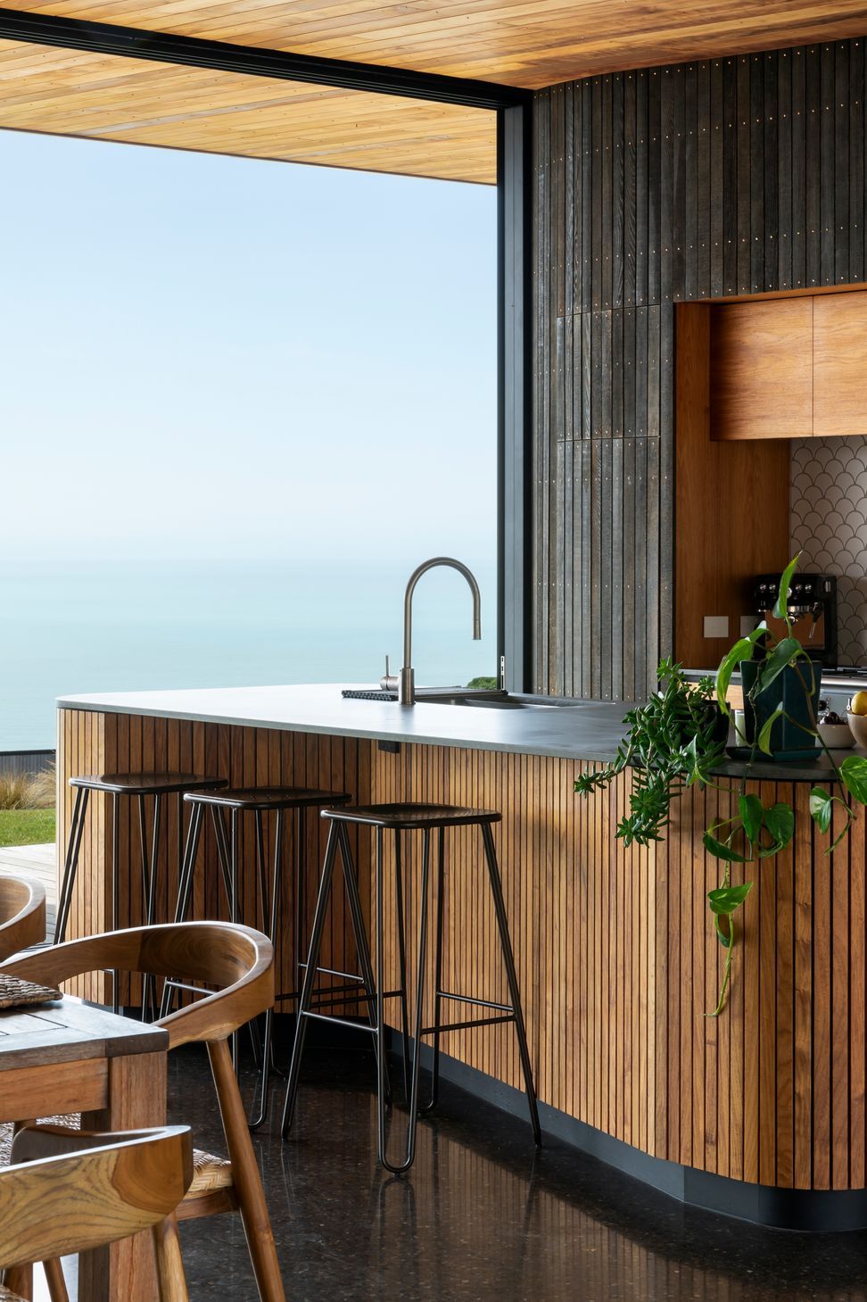 The kitchen island reflects the same curves and warm materiality as the rest of the house.