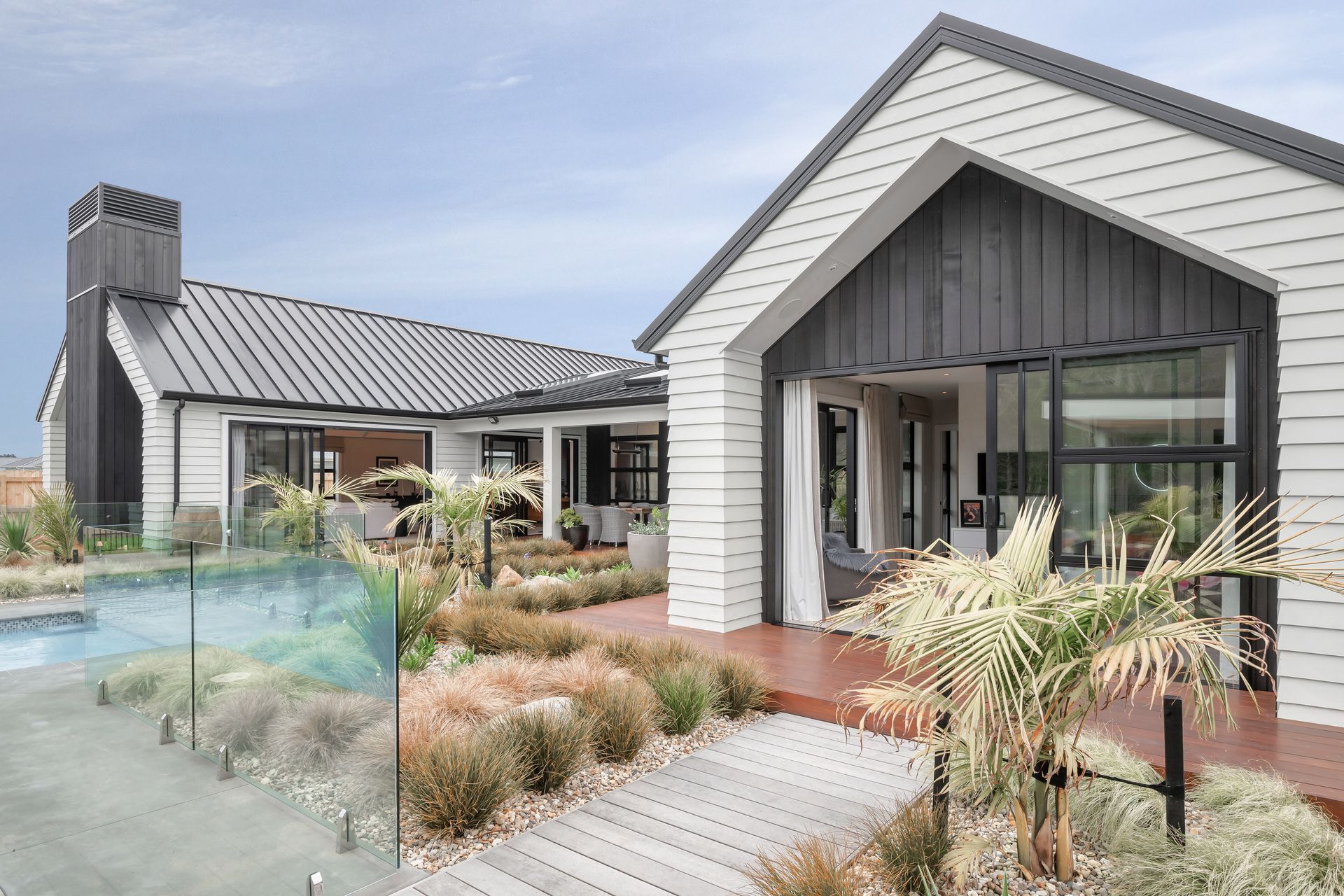 The glass pool fencing and casual landscaping makes you feel as if there is no division between the outdoor living and pool spaces.