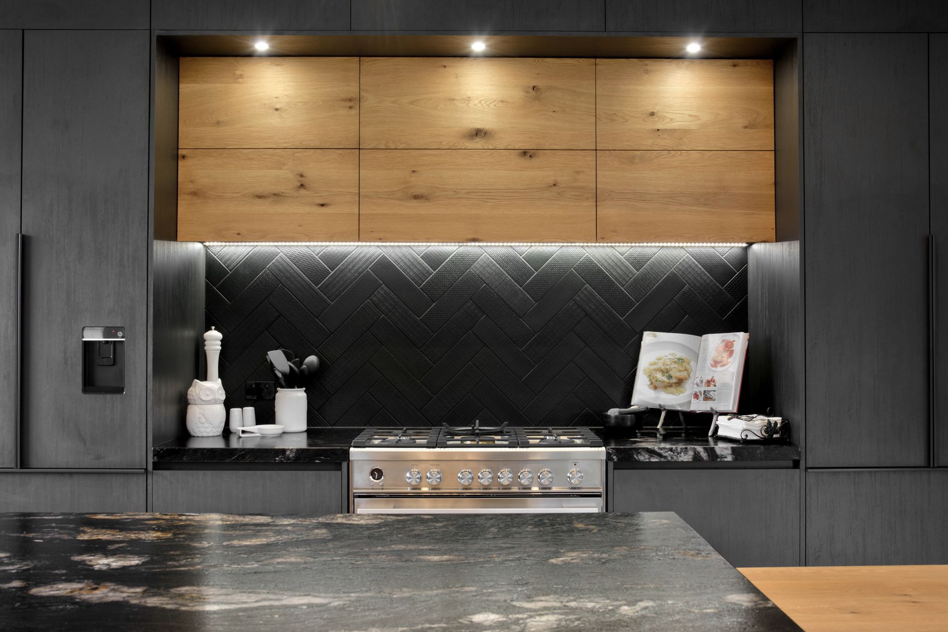 The gorgeous granite and herringbone tiles of the kitchen create a feature splashback.