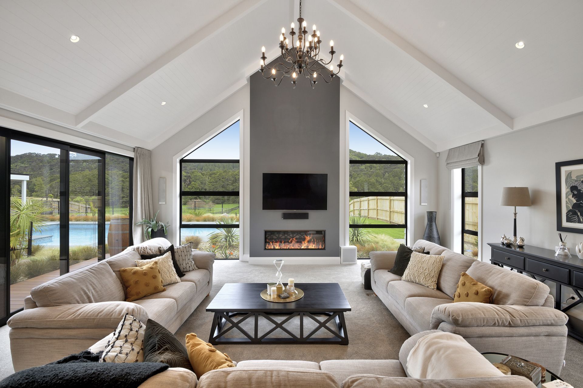 The lounge space with gas fire looks out to the pool and bush beyond.