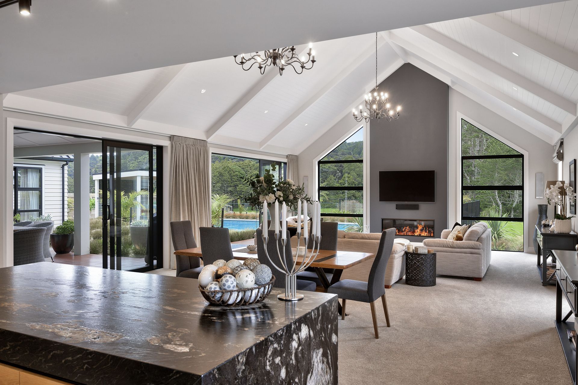 Within the larger wing, kitchen, dining and living areas sprawl across a grand room with spectacular high-pitched cathedral ceilings and extensive views of the native bush.
