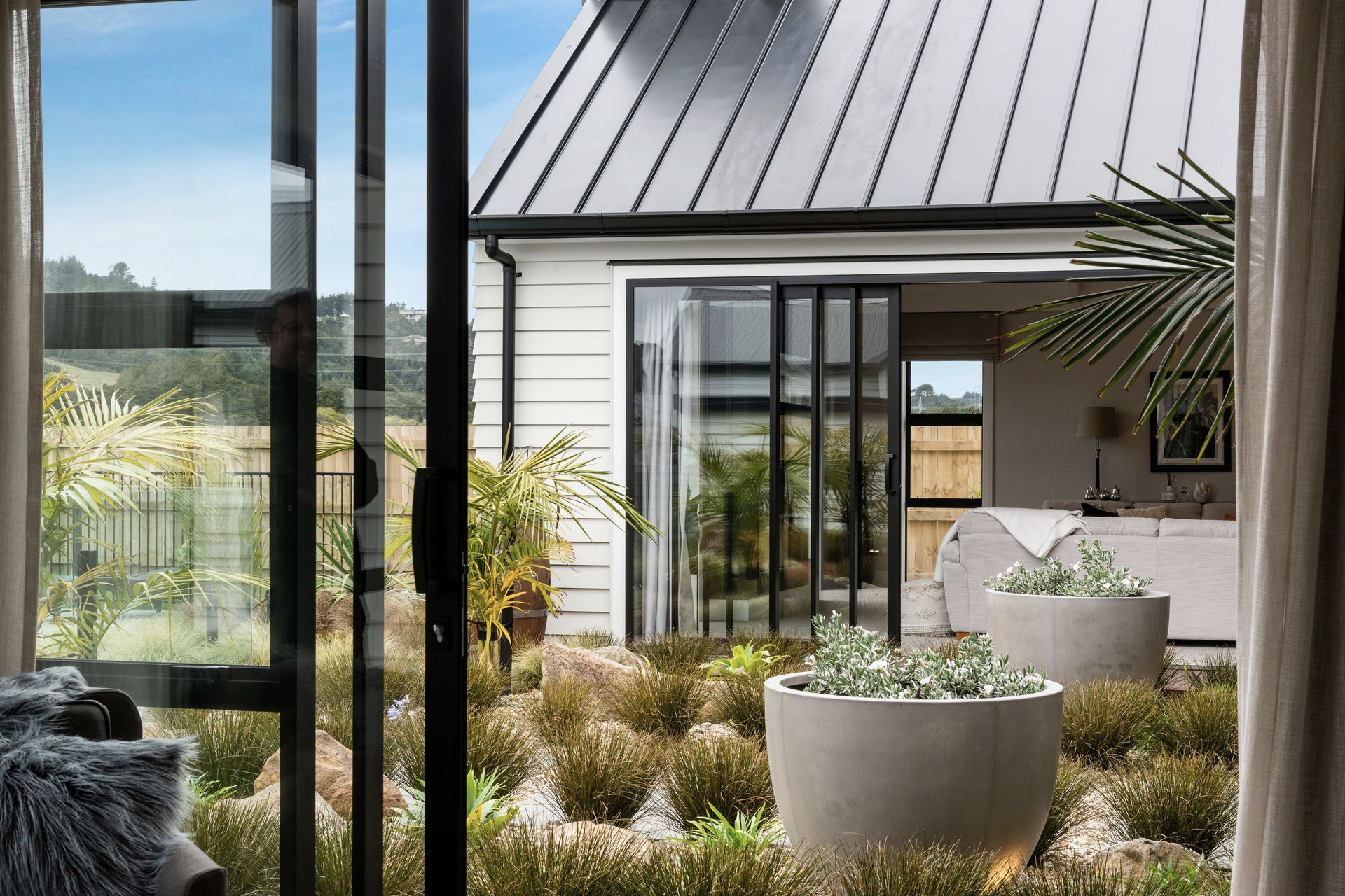 The outdoor space between the two sides of the 'H' is artfully landscaped with easy-care planting.