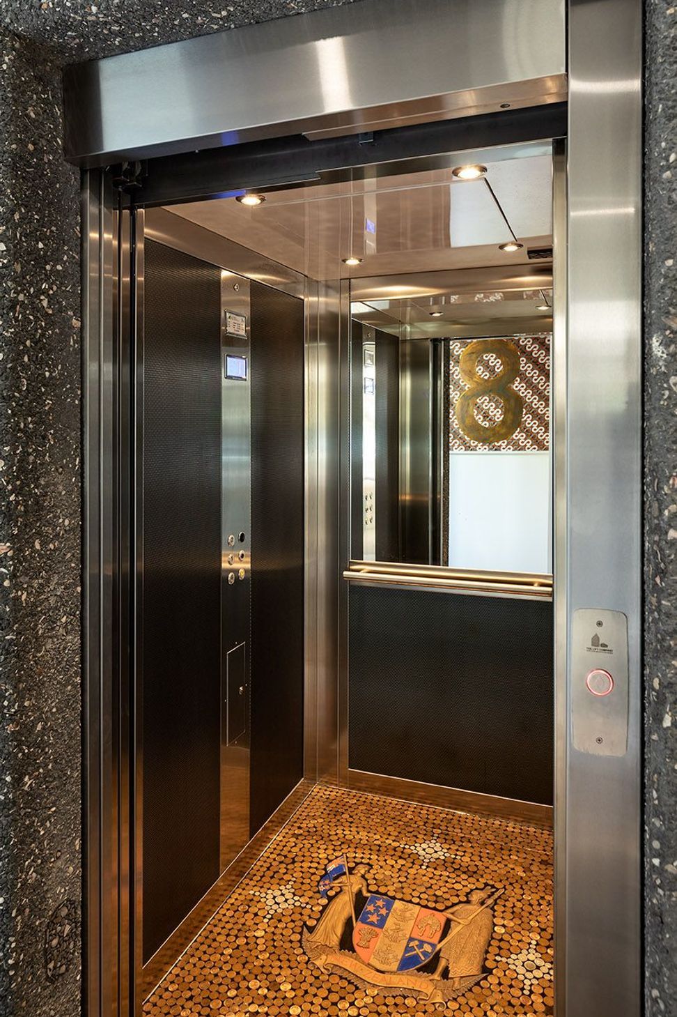 A full commercial lift connects all three levels of the home, combining accessibility with exceptional craftsmanship. The bespoke lift floor, created using vintage New Zealand coins, introduces a unique detail that reflects the individuality of the project.