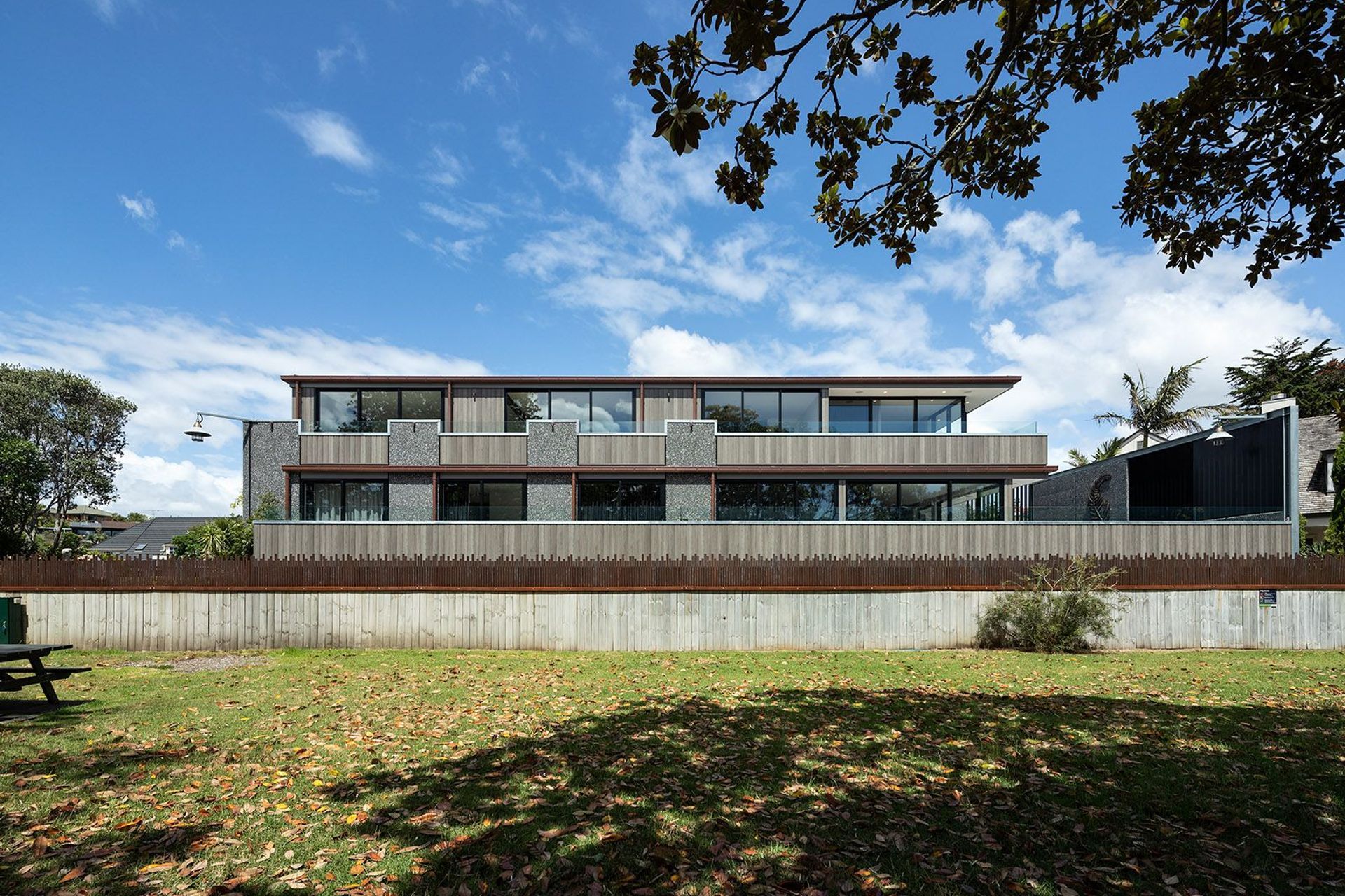 Viewed from the neighbouring park, the home presents a striking sculptural form that combines tilt slab concrete, timber cladding and expansive glazing. The carefully articulated façade creates a timeless expression of contemporary New Zealand architecture.