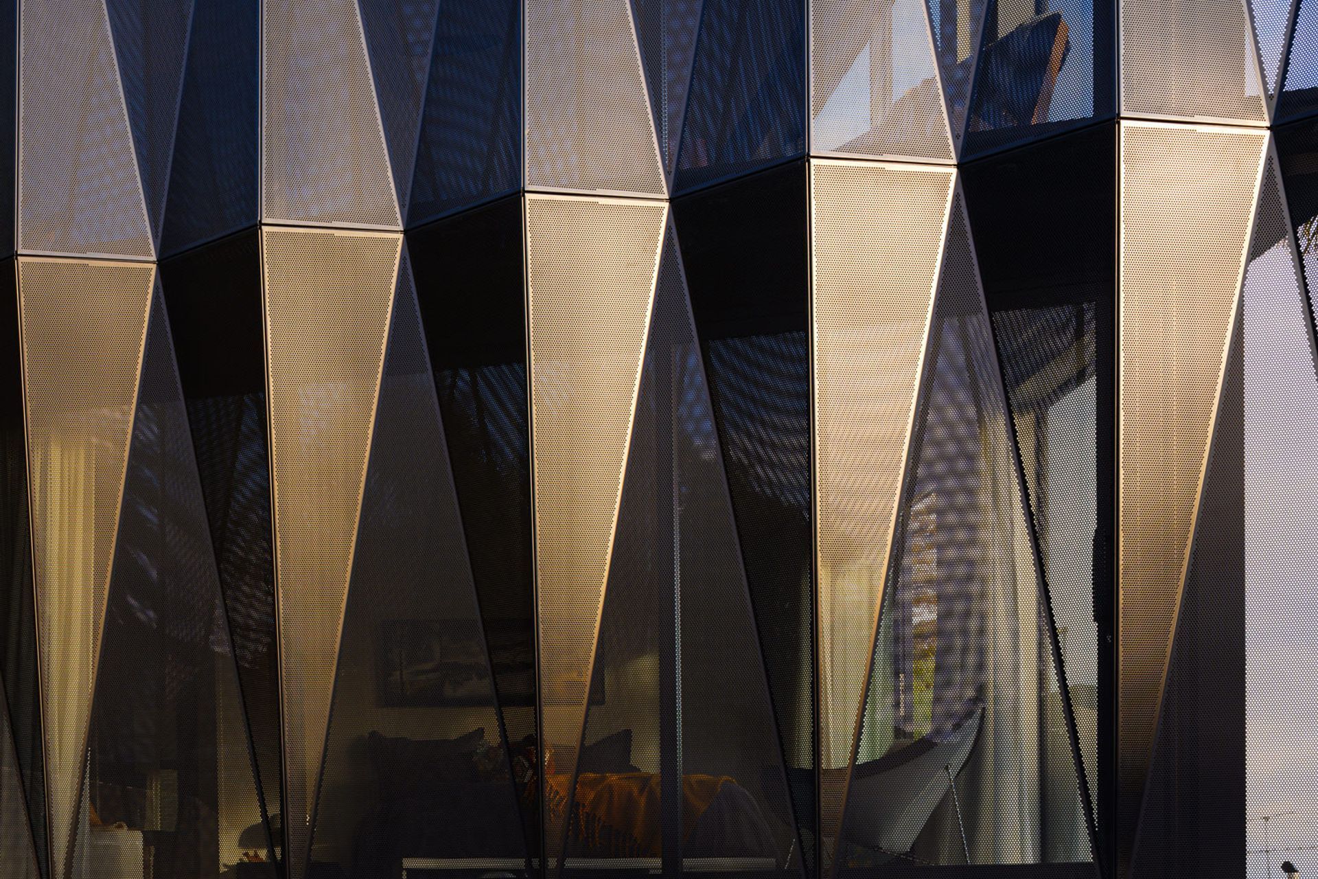 Geometric shade fins made from perforated, powder-coated aluminium were devised to address issues around light, shade and privacy on the east-facing street frontage.