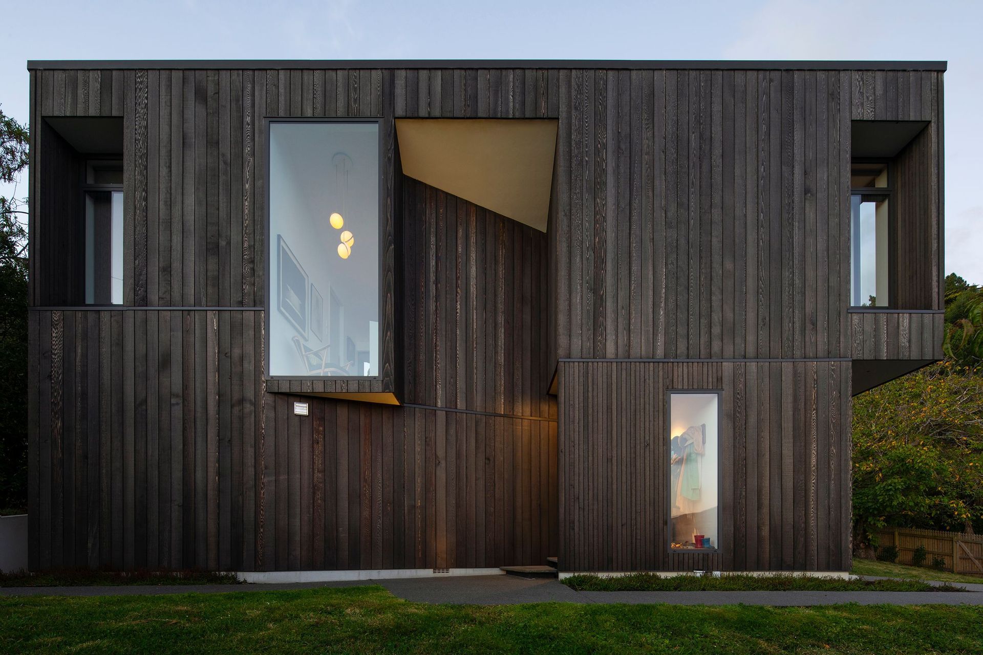 The home's folded geometry celebrates strong shapes with interesting cut-outs that reflect the nearby rocky outcrop of the Port Hills.