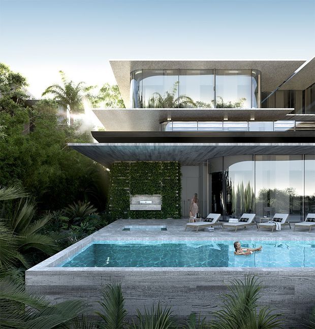 A contemporary multi-storey residence with broad cantilevered floor plates, curved floor-to-ceiling glazing, and a rooftop-like upper terrace. The home overlooks a turquoise swimming pool with a raised textured concrete surround, outdoor loungers, dense tropical landscaping, and a vertical green wall with an integrated outdoor fireplace or feature element. The composition has a polished architectural-rendering quality and emphasizes indoor-outdoor living.