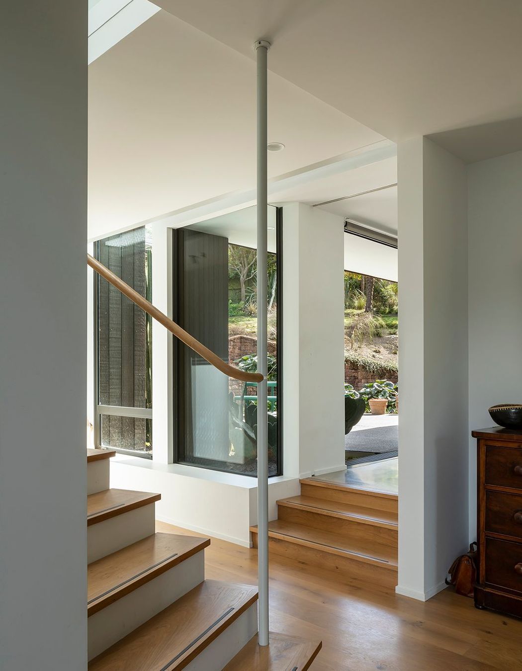 The stair has a a certain playful artistry, with the newell post connected to the beam above, which leaves the last five or six risers 'floating'.