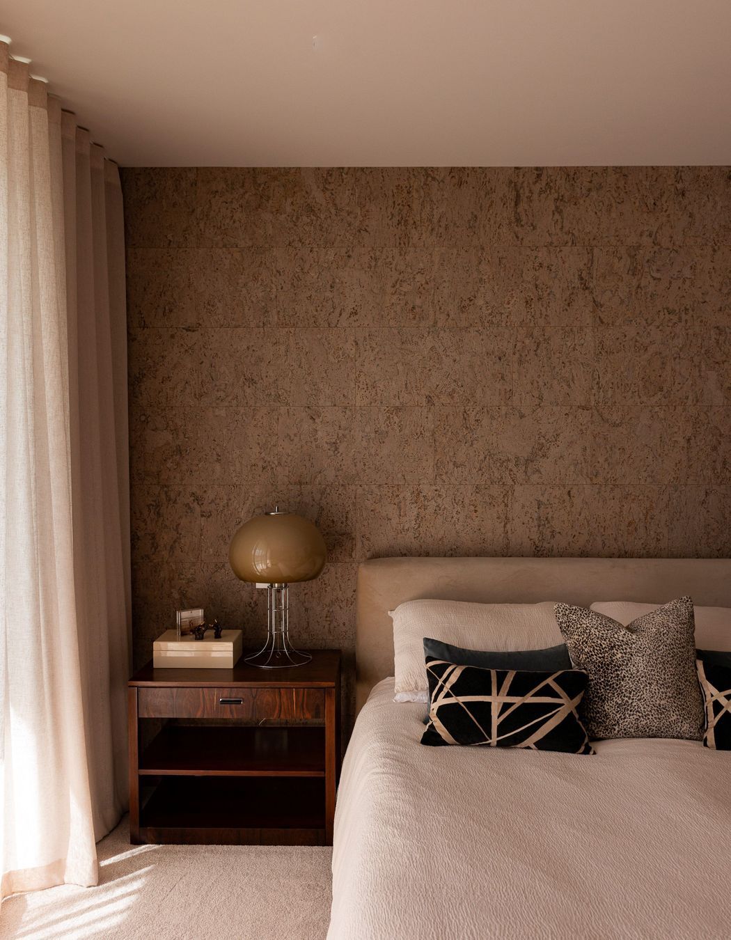 The cork feature wall brings warmth and texture to the bedroom.