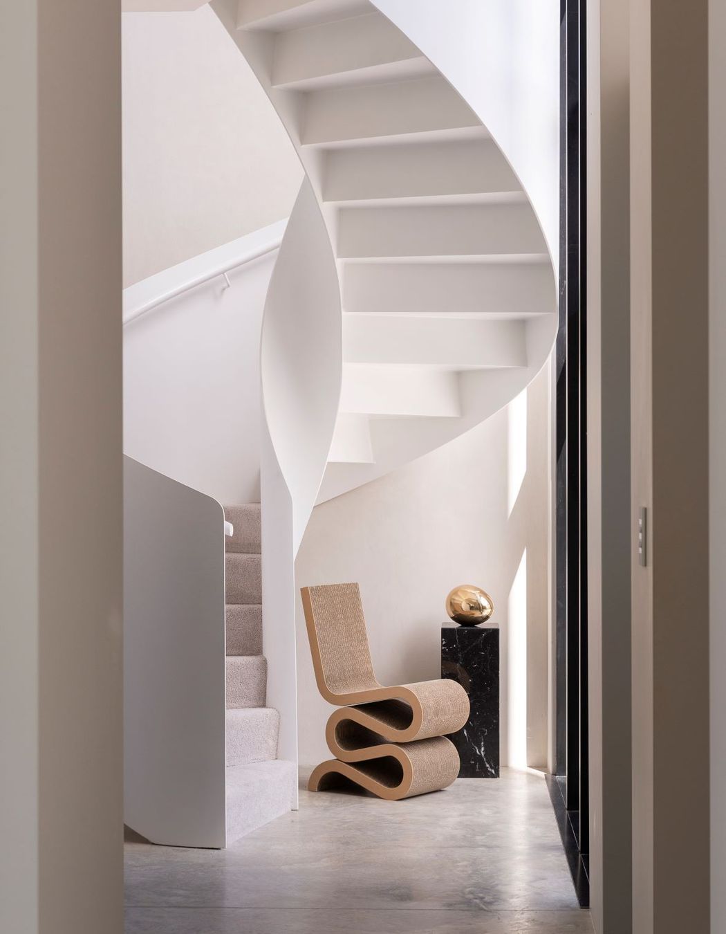 The spiral staircase, made from steel, commands attention in the entrance way.