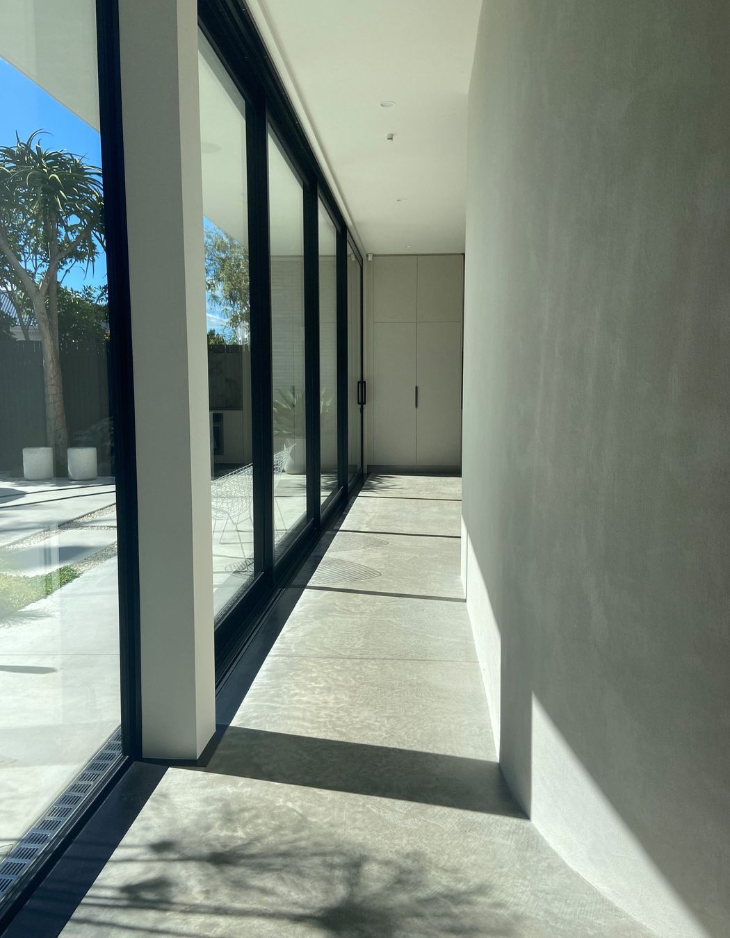 The gentle curve of the hallway wall guides you into the open-plan kitchen, dining, and living space.