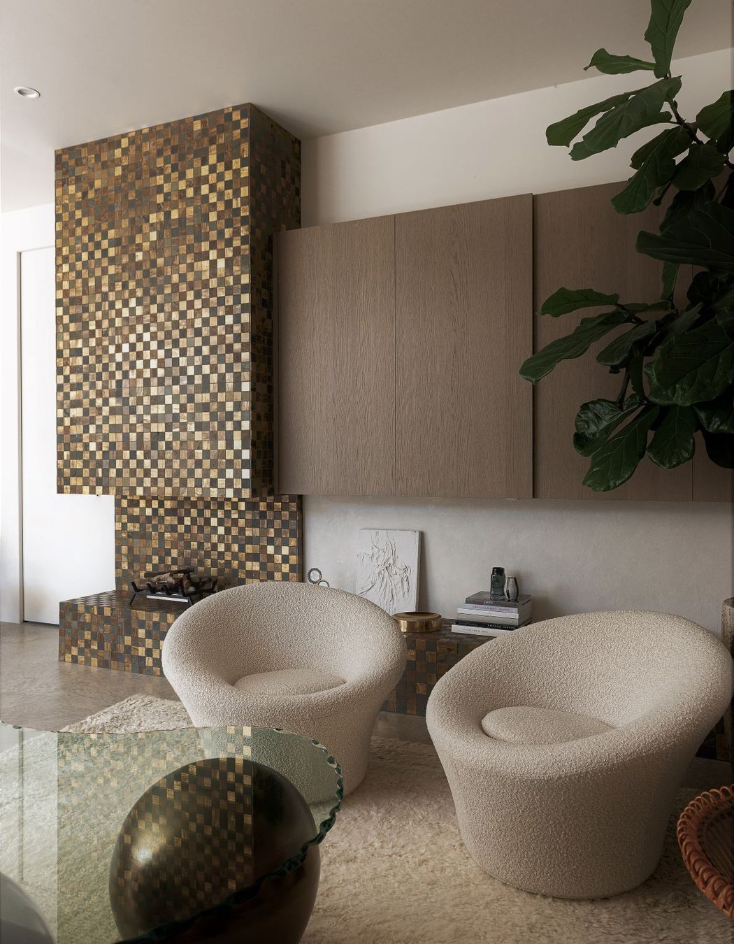 Tiny brass tiles were used to create this glittering façade for the fireplace, hearth, and chimney.