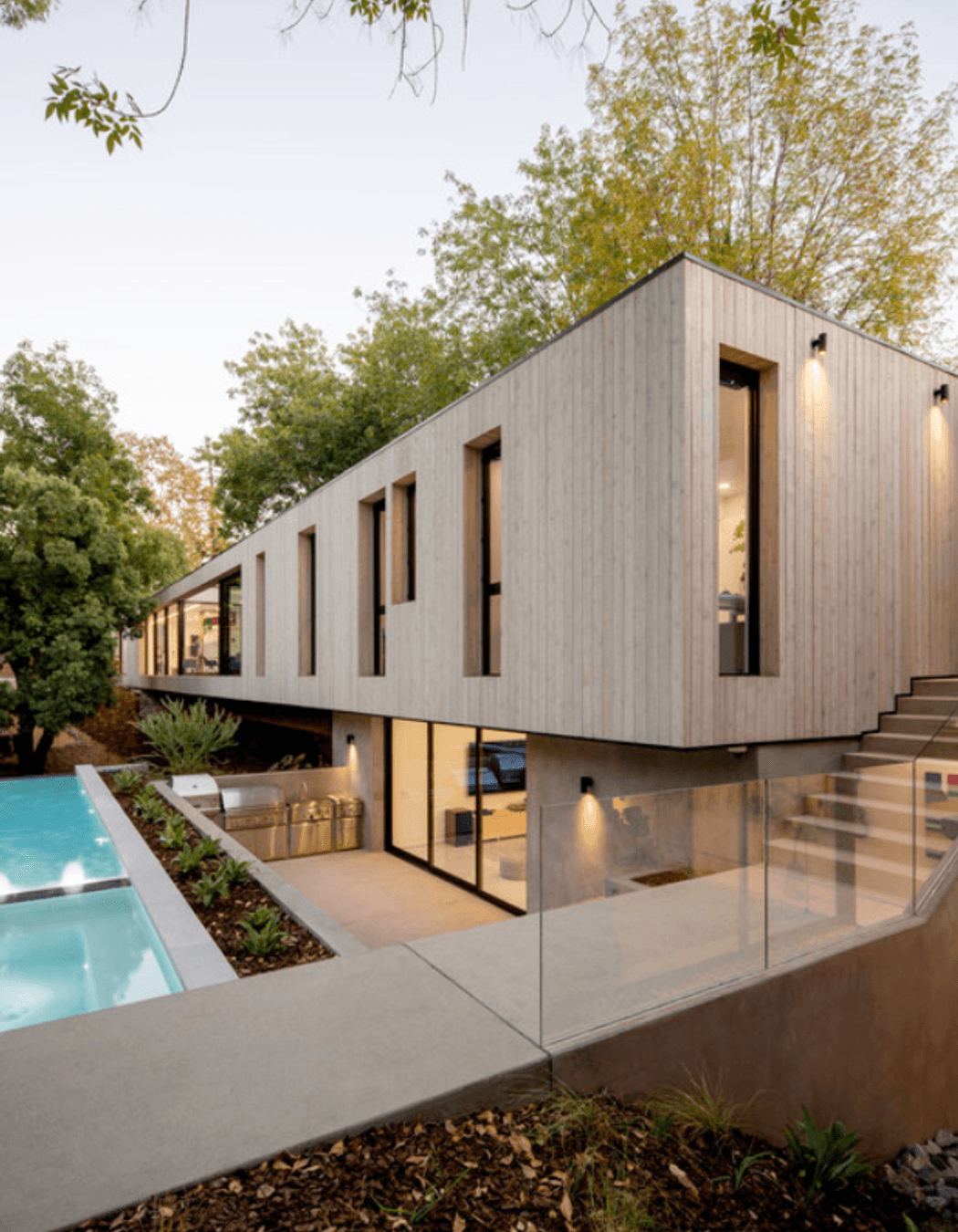 The exterior matches the minimalist aesthetic of the interior design - seen in the square-set timber façade and backyard pool area.