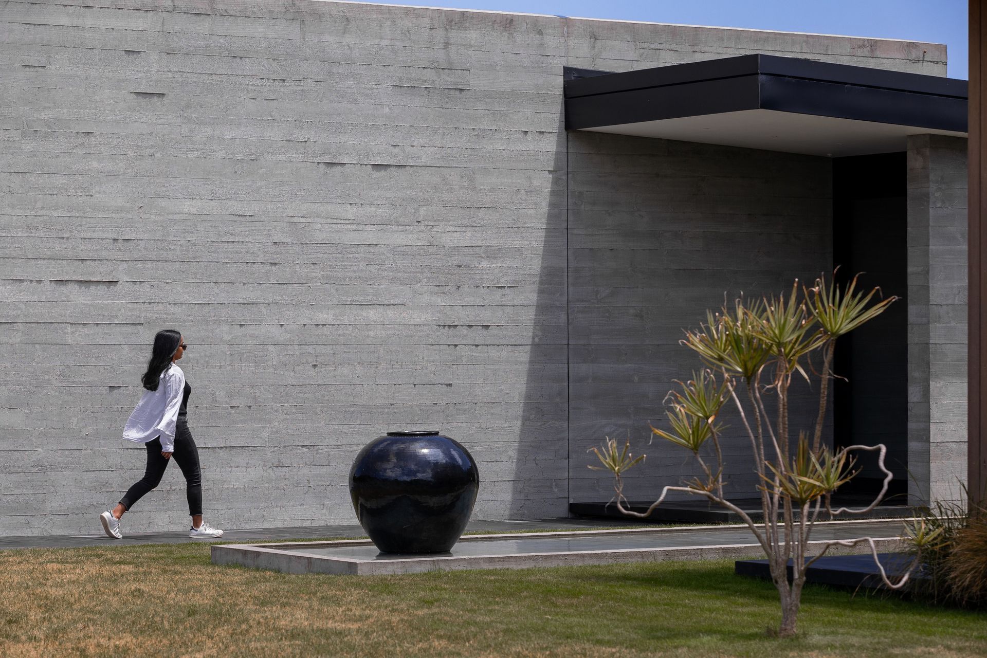 Insitu-concrete walls lead past the reflection pool to the entry.