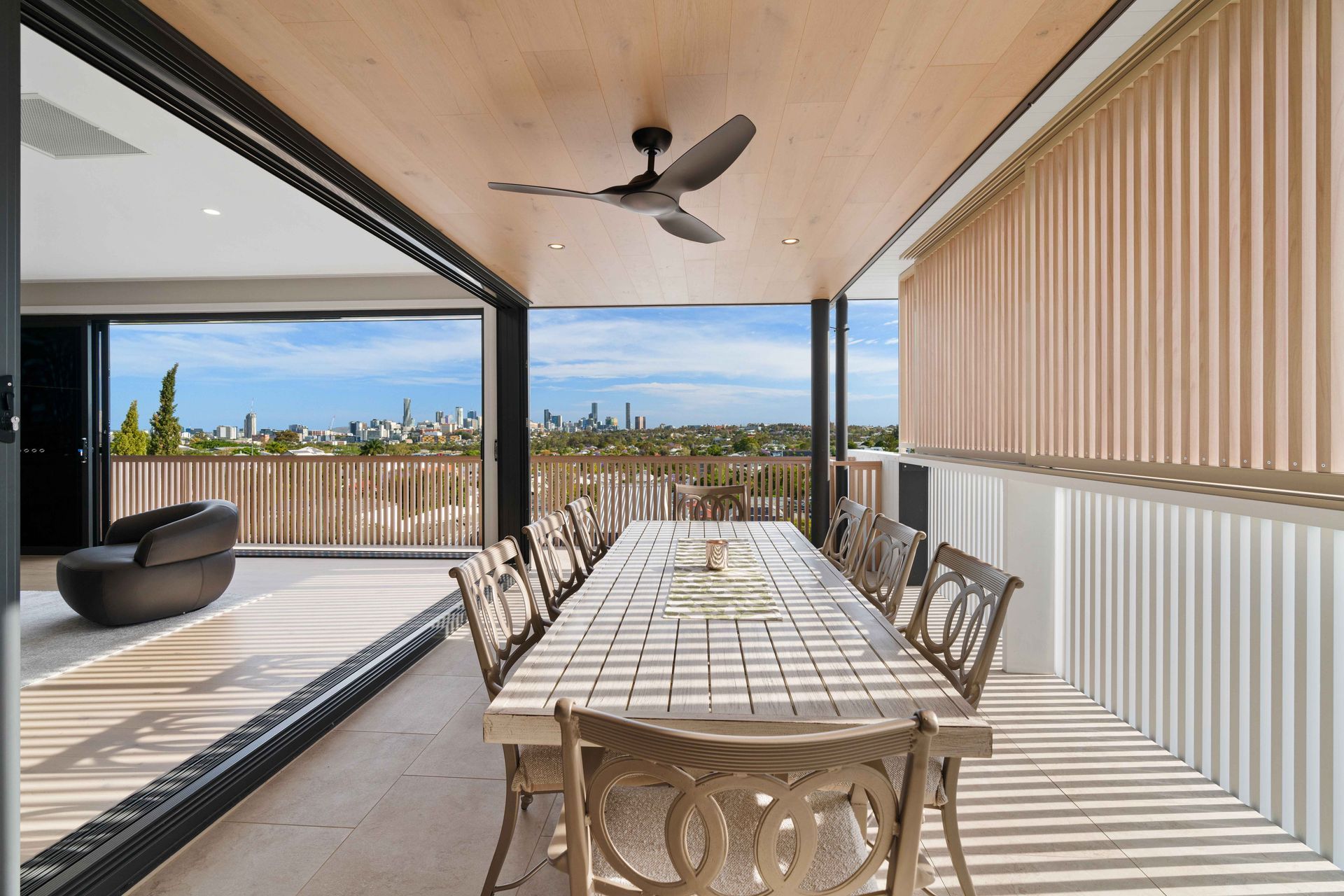The upper balcony frames the city skyline through a screen of timber slats.