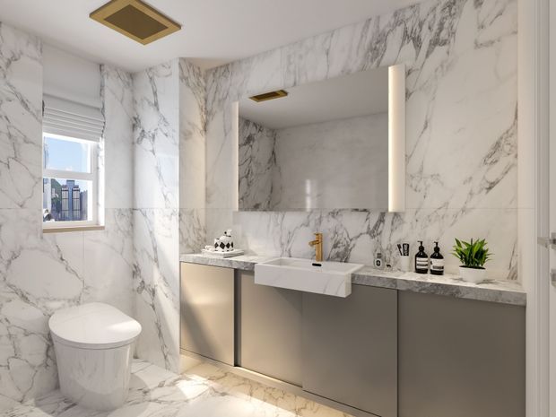 A refined contemporary bathroom featuring dramatic white marble-effect wall and floor surfaces with grey veining, a floating double vanity in matte grey cabinetry, a white integrated basin, brushed gold tapware, a large illuminated mirror, recessed gold-accent ceiling lighting, and a wall-mounted toilet. A window provides natural light, while black accessories and a small green plant add contrast.