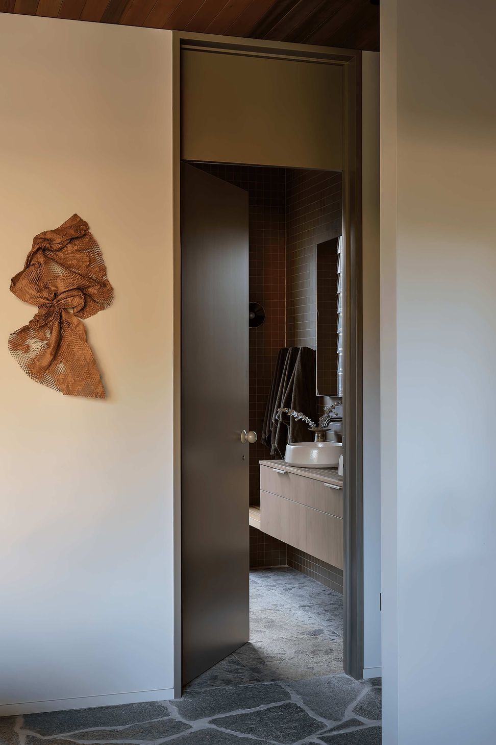 In the bathrooms, Novara Technifirma mimics the ambient movement of flecked terrazzo while Nacre glass mosaic tiles add vibrant green sparkle to the organic-shaped pool.