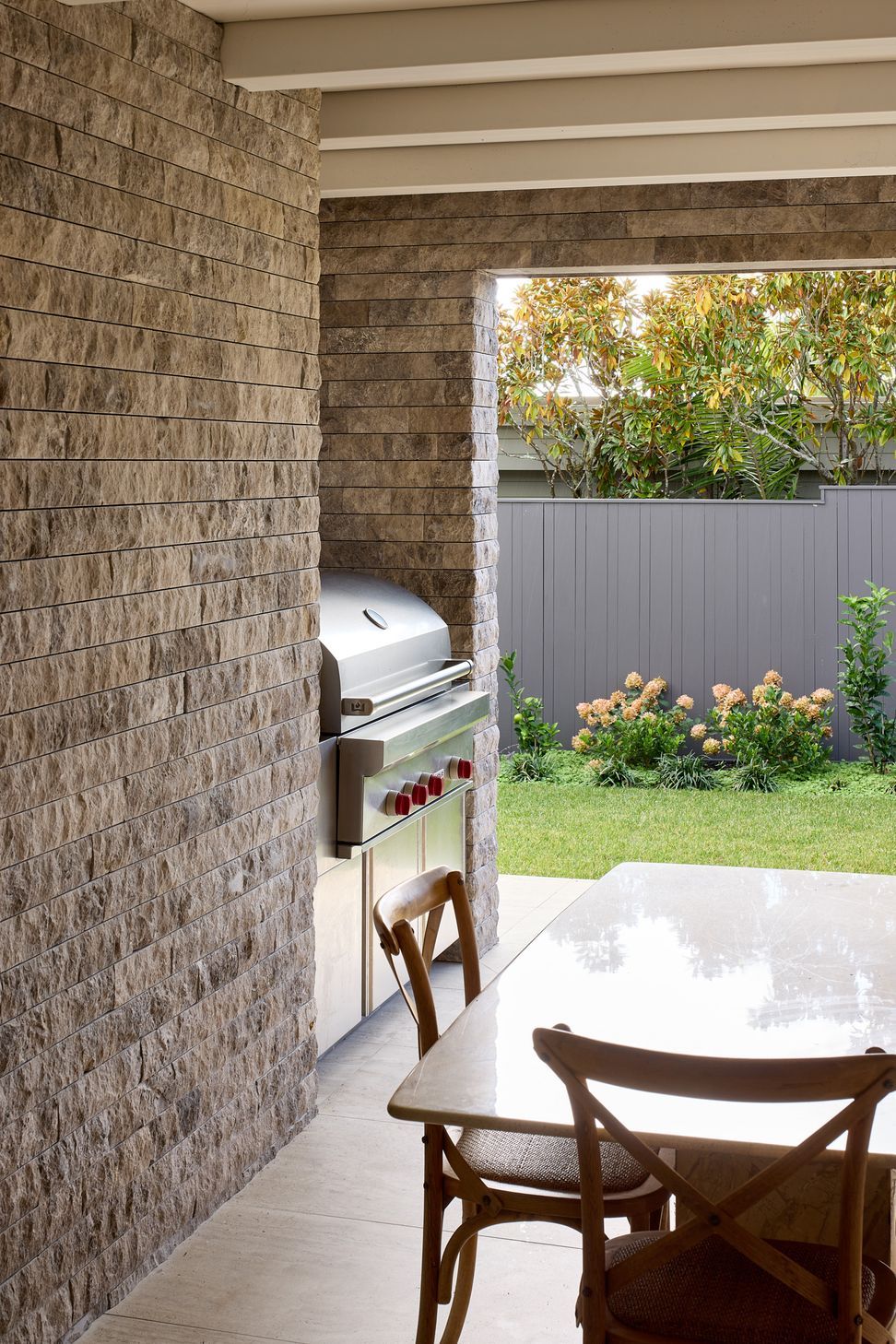The covered outdoor room on the ground floor provides a sheltered setting for year-round entertaining. A built-in barbecue, generous dining area and direct connection to the garden create a relaxed extension of the home.