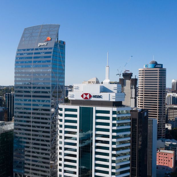 A daylight cityscape showing several prominent commercial office towers, including the HSBC building in the foreground, a curved glass PWC tower to the left, and the rounded ANZ tower to the right. The image focuses on dense urban high-rise architecture with glazed facades and rooftop signage.