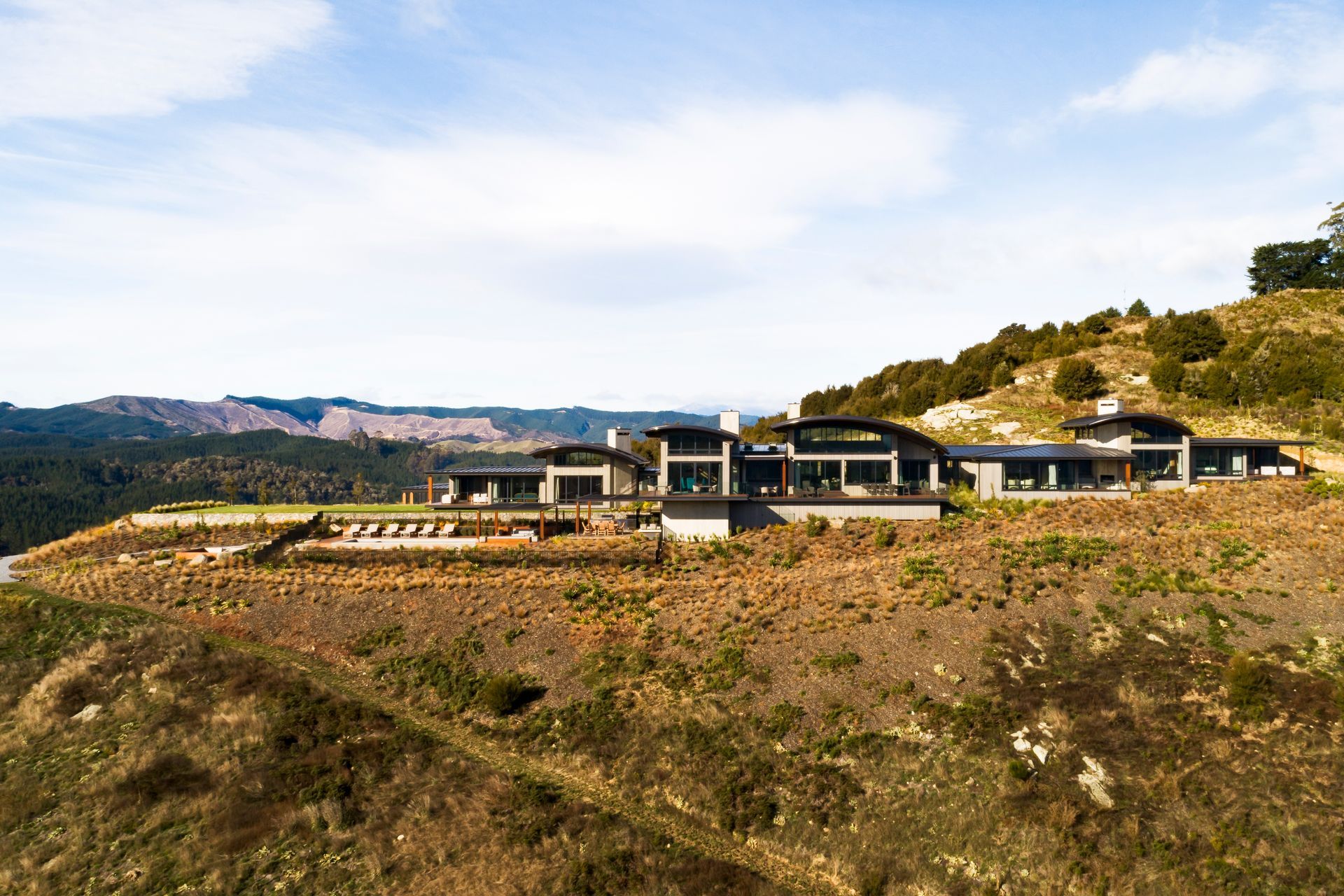 The elliptical forms of the rolled steel roofing mimic the shape of a falcon's wing and create expansive five-metre high volumes on the interior.