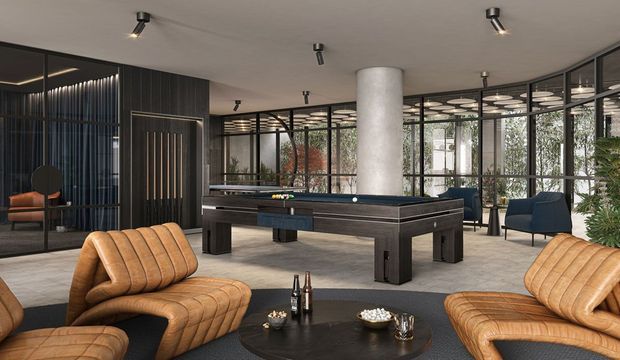 A sophisticated contemporary games and lounge room featuring a full-size billiards table, sculptural curved concrete column, extensive black-framed glazing, dark timber wall panelling, and low-profile ceiling spotlights. Cognac leather lounge seating surrounds a dark round coffee table, while planted greenery and outdoor views are visible through the glazed walls.