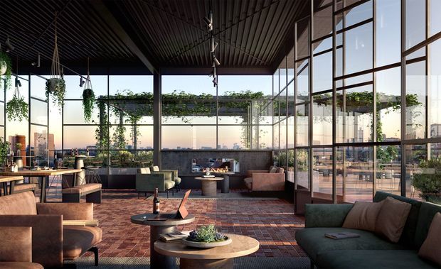 A sophisticated rooftop or high-rise communal lounge with extensive floor-to-ceiling glazing, a dark ribbed ceiling, exposed structural framing, hanging and climbing greenery, and panoramic urban views. The space includes clustered lounge seating, low round coffee tables, a dining or work table, and a warm patterned carpet. The interior has a refined contemporary hospitality-style atmosphere with strong indoor-outdoor visual connection.