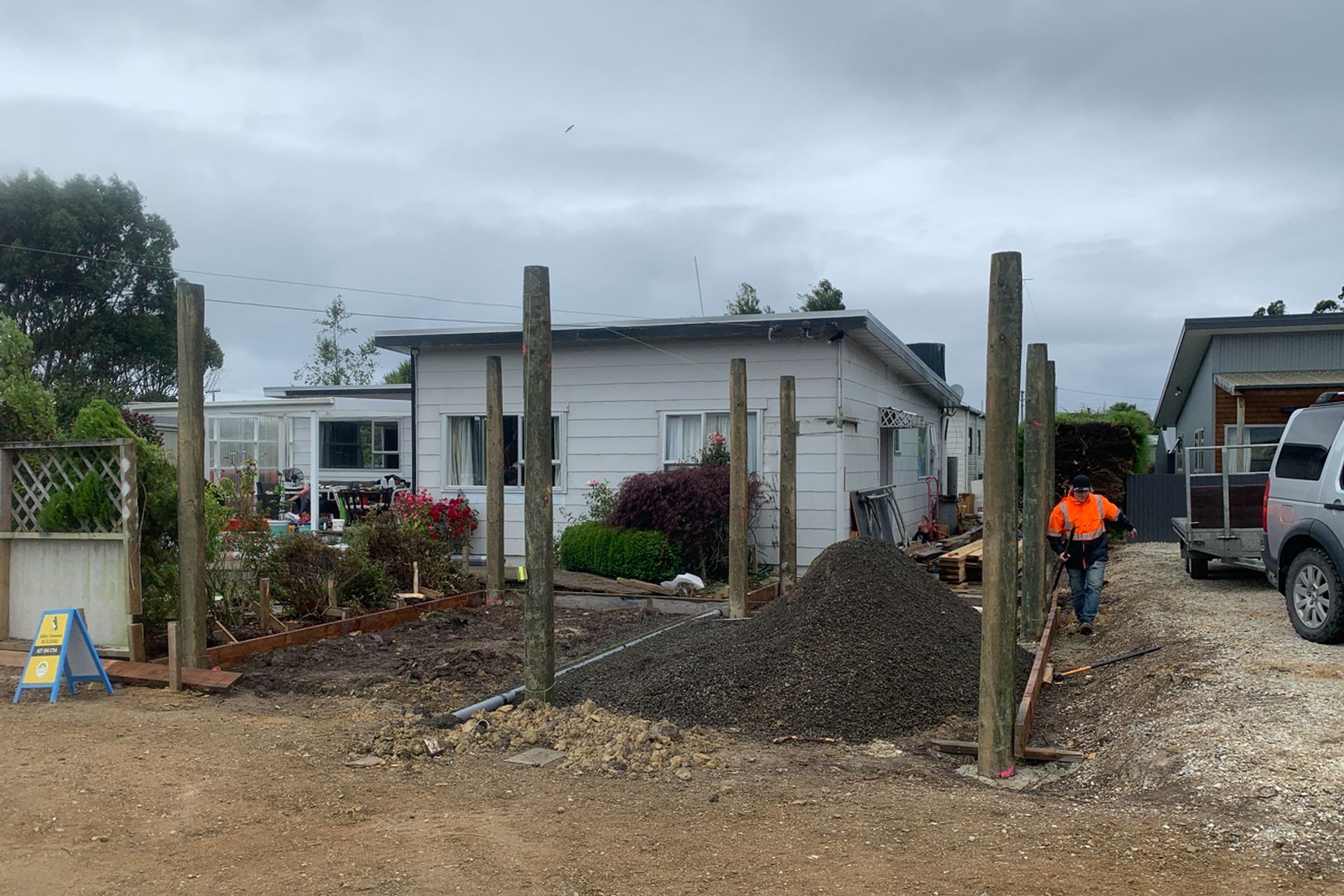 Concrete placed in post holes, base gravel ready to be spread out.