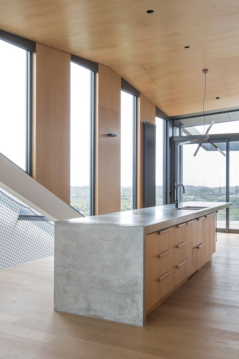 Window slots cut into the north wall provide panoramic coastal views and solar penetration for passive-heating