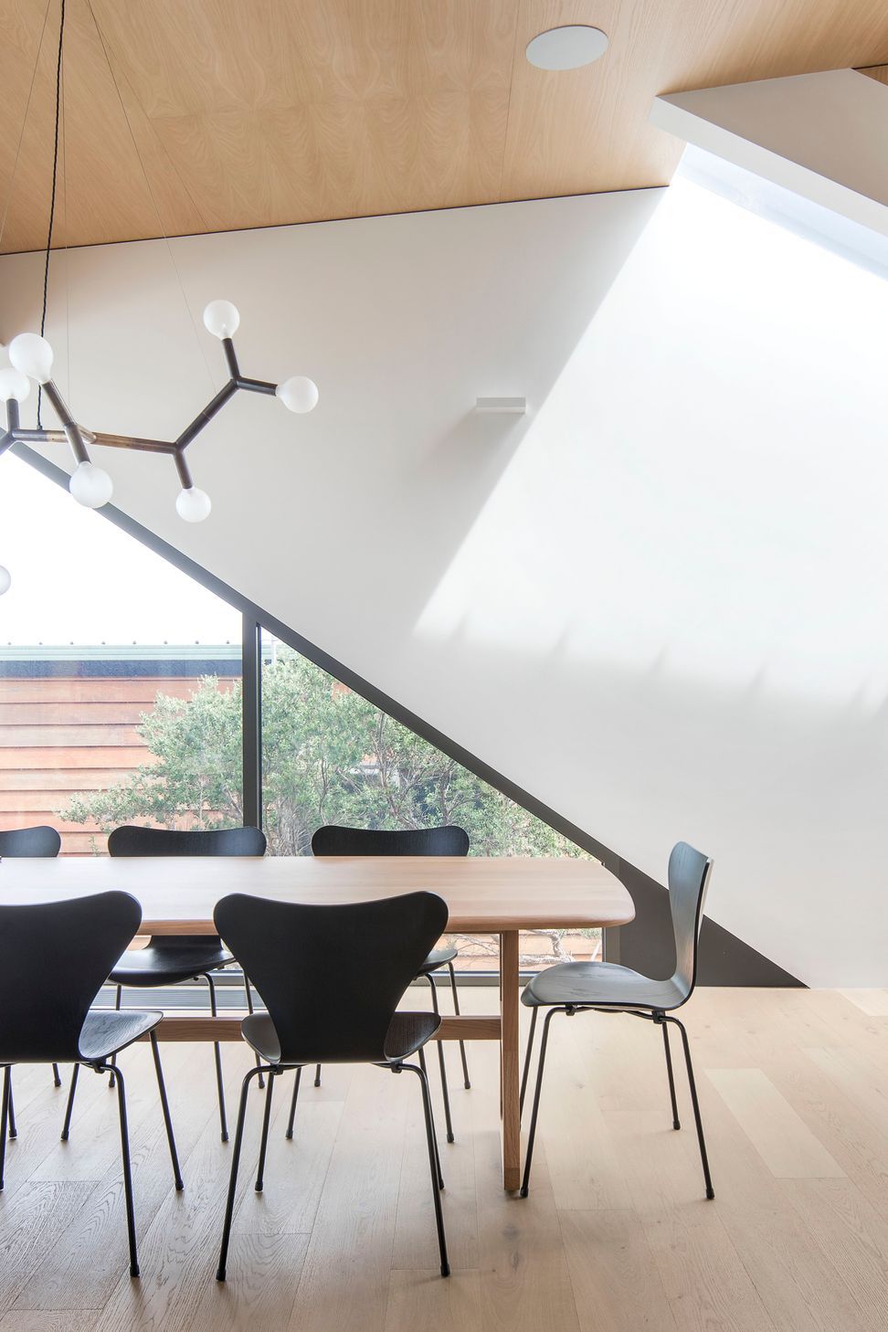 Geometry features in the dining space, highlighted by an organic-shaped pendant light and angled window lines.