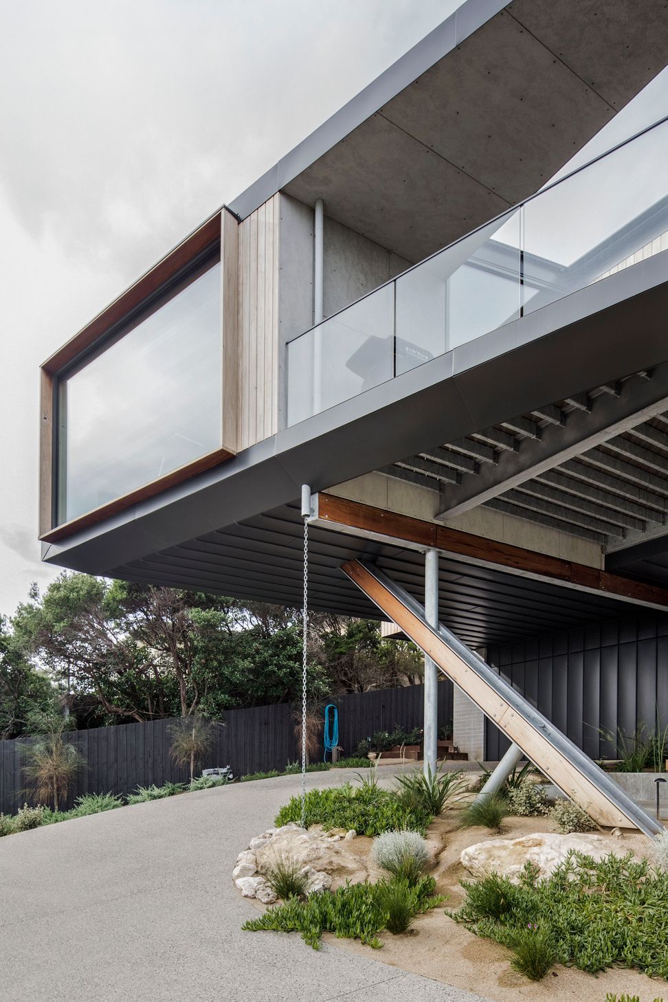 Exposed timber and steel cross-legs define the distinct architectural expression of this elevated coastal home