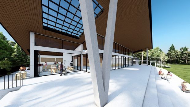 A bright architectural rendering of a modern multi-level pavilion or communal building set within a landscaped green site. The image focuses on a large covered terrace with dramatic V-shaped structural columns, extensive floor-to-ceiling glazing, a deep timber-lined soffit, and a prominent glazed roof section that brings daylight into the interior. People and lounge seating are visible on the broad concrete terrace, while an open interior space with counters or communal furnishings can be seen through the glazing.