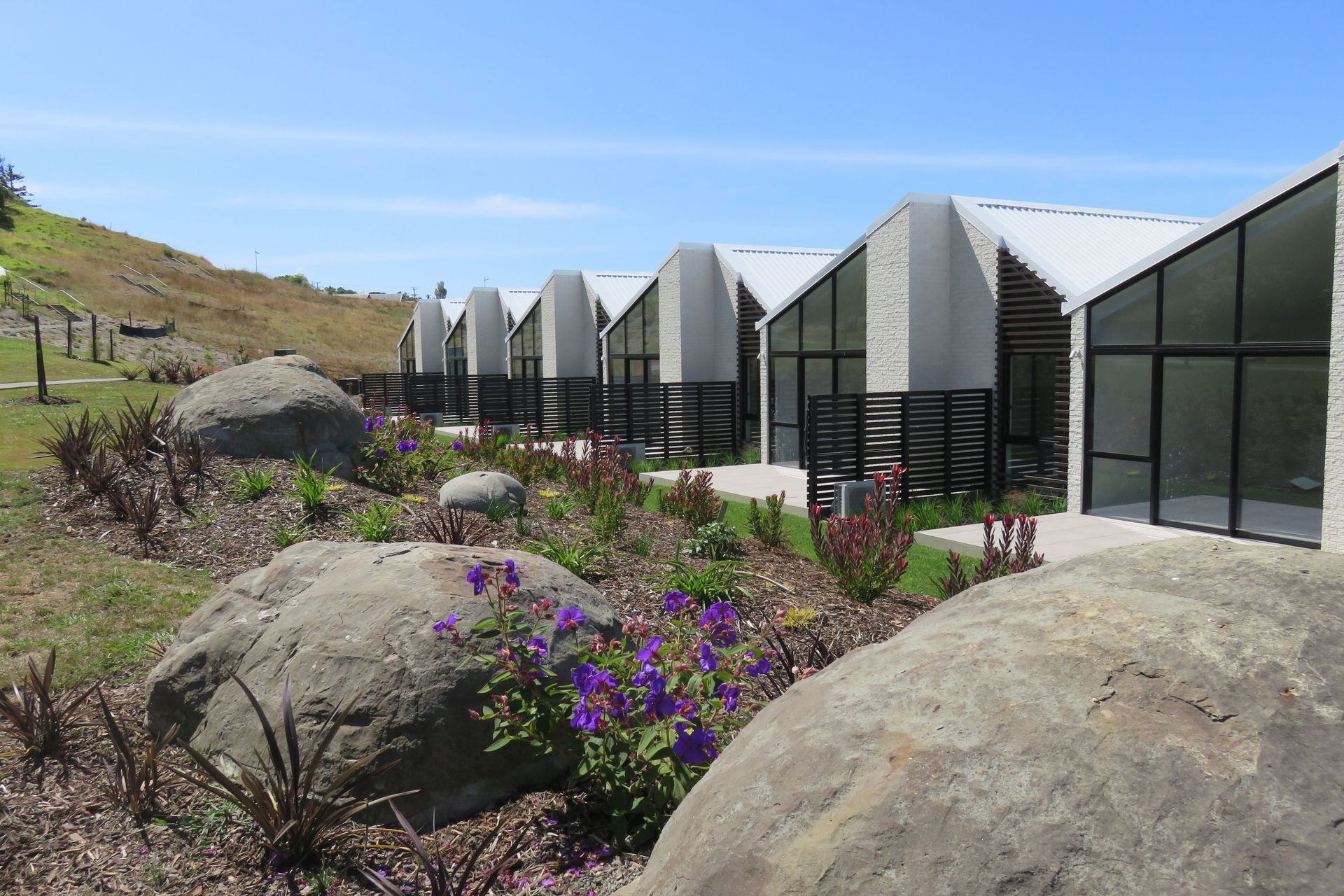 Large boulders have been incorporated throughout the landscaping as natural play elements for children.