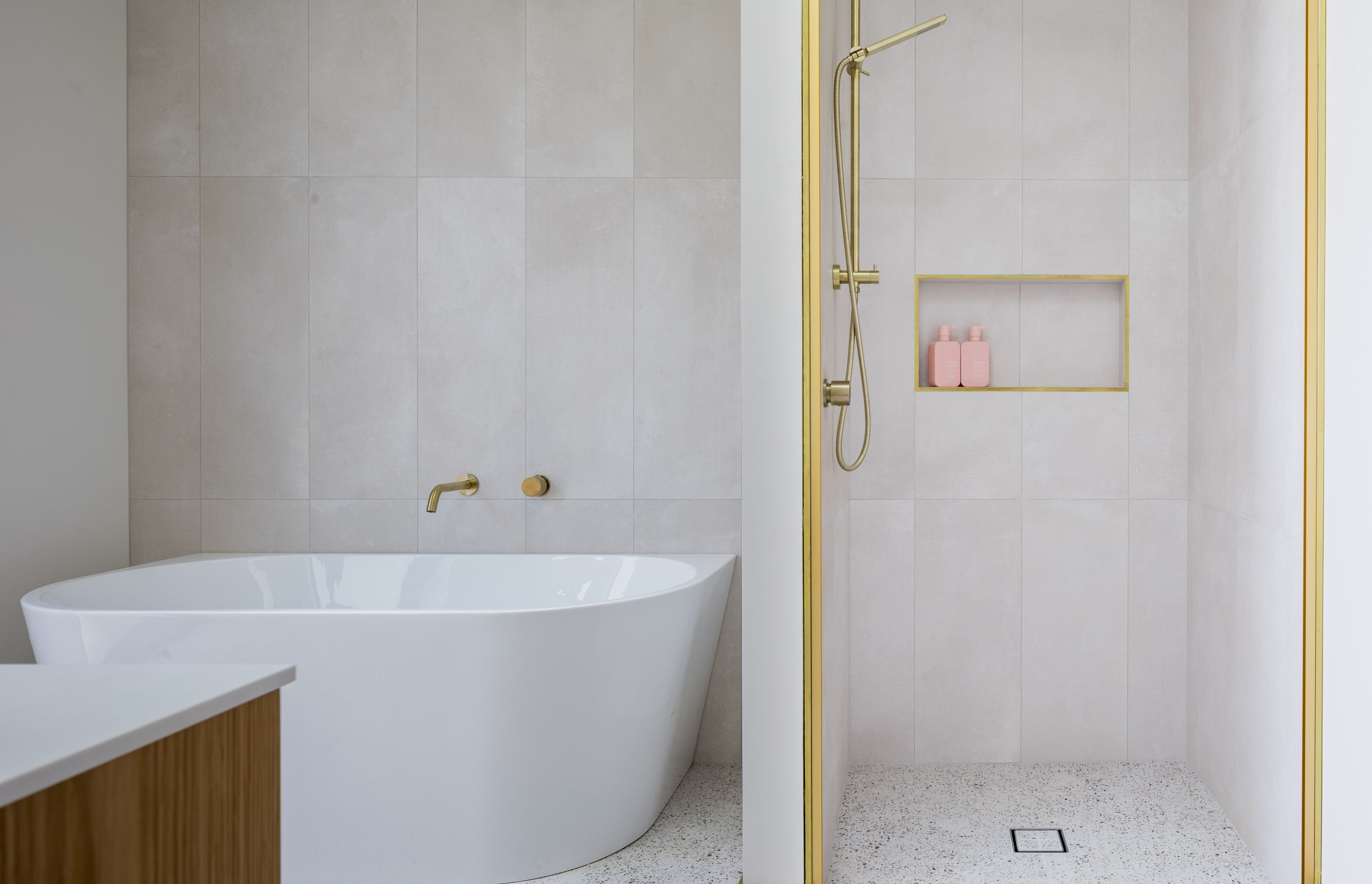 Natural tones and brass highlights create a luxurious aesthetic in the main bathroom.