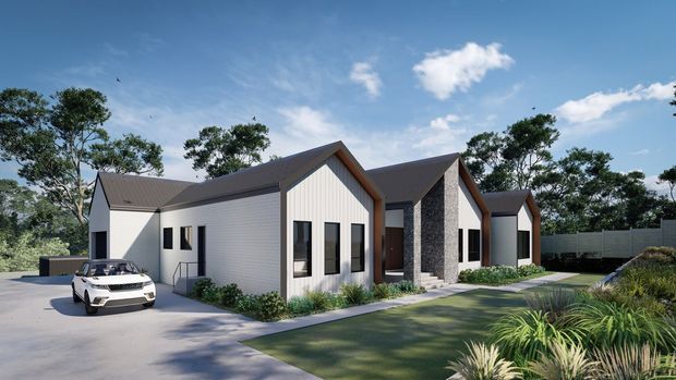 Exterior architectural rendering of a contemporary single-storey residential development composed of several connected gabled volumes. The facade combines light vertical cladding with dark textured masonry feature walls, dark pitched roofs, and simple black-framed windows. A paved driveway, landscaped front garden, boundary fencing, and a parked car are visible under a bright blue sky.