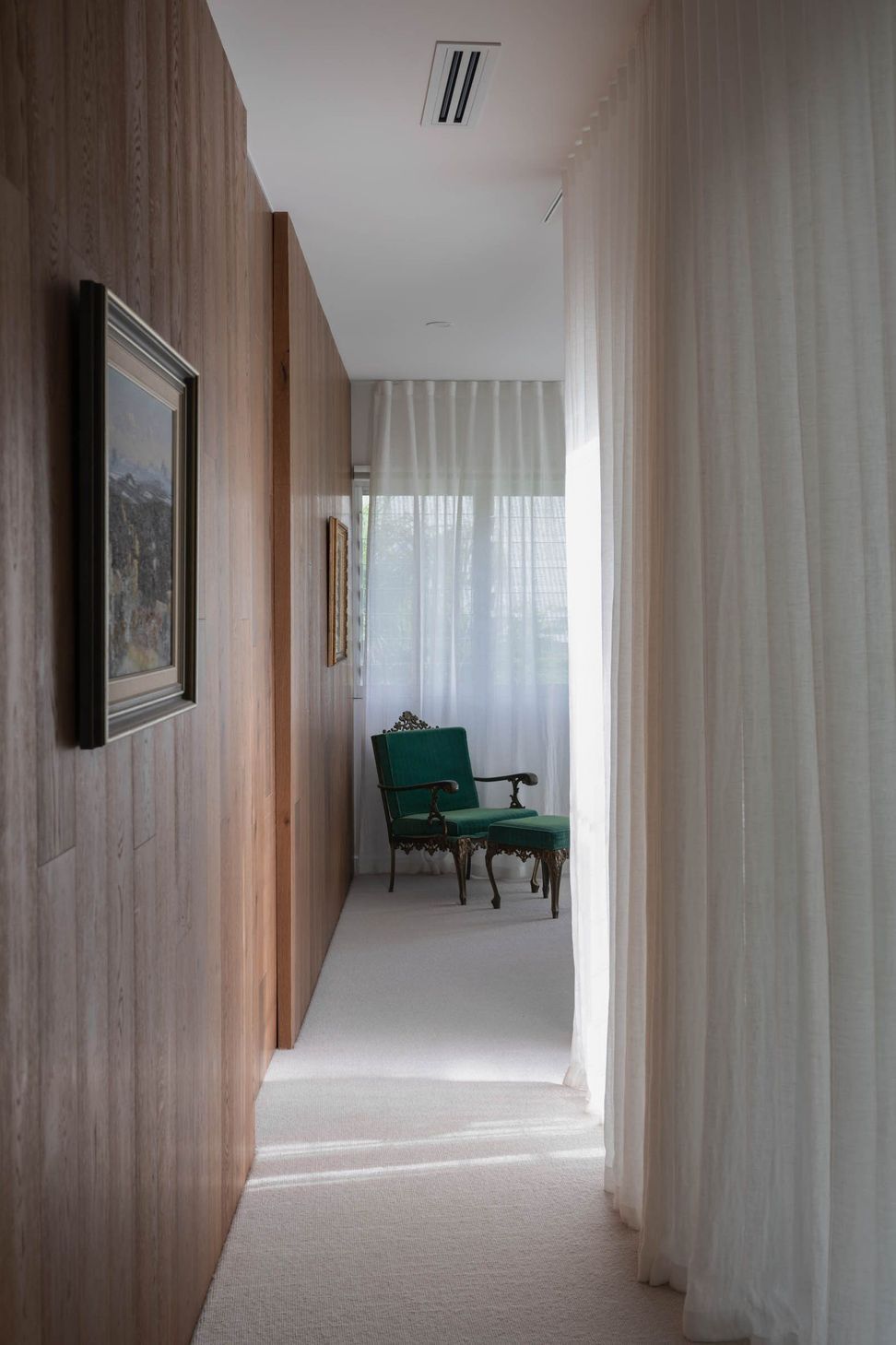 Eleutheria - Hall. Timber lined hallway leading to a reading nook.