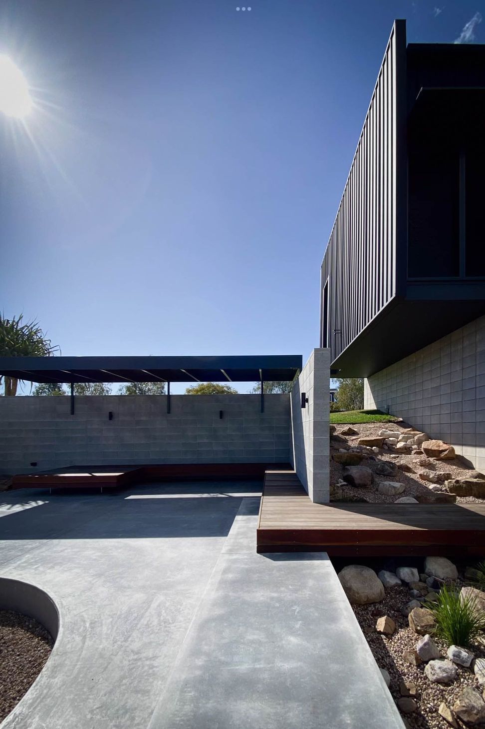 Seabrook and Borg Residence - Patio. Covered terrace and garden beds below the cladding.