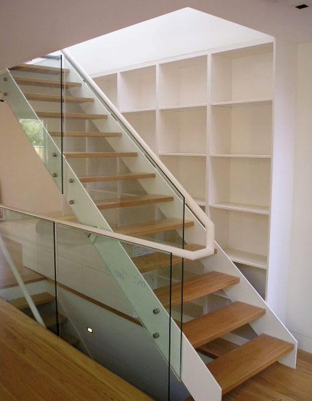 Timber, steel and glass feature stair with shelving behind