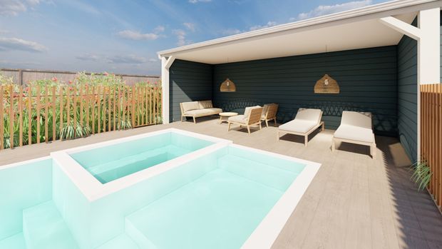 A bright outdoor pool and spa area beside a covered lounge pavilion. The space features a pale timber-look deck, white-framed open-sided structure, dark horizontal wall cladding, woven pendant lights, and light outdoor loungers. A timber privacy screen and landscaped planting border the pool, with open sky beyond.