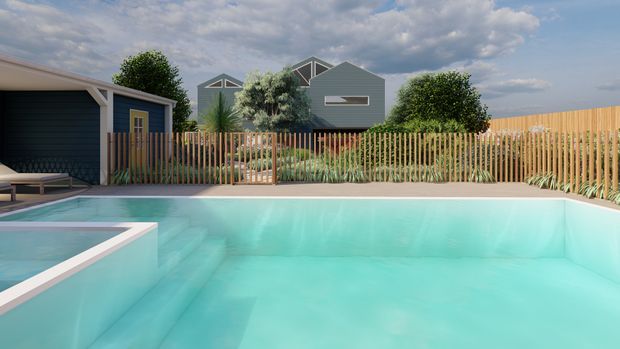 Contemporary residential backyard dominated by a large pale turquoise swimming pool with broad submerged steps and a raised square spa at left. A timber slat fence, landscaped planting, and a compact dark-clad poolhouse or garage sit behind the pool, with additional modern gabled homes visible beyond.