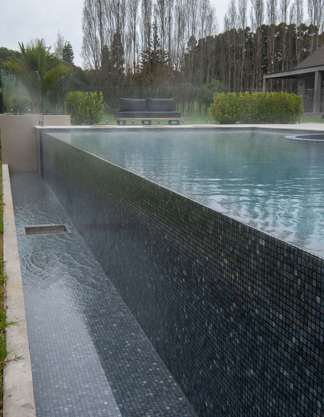 The fully tiled infinity wall and trough is a beautiful feature using the Dolerite Tile from the Ezarri Range