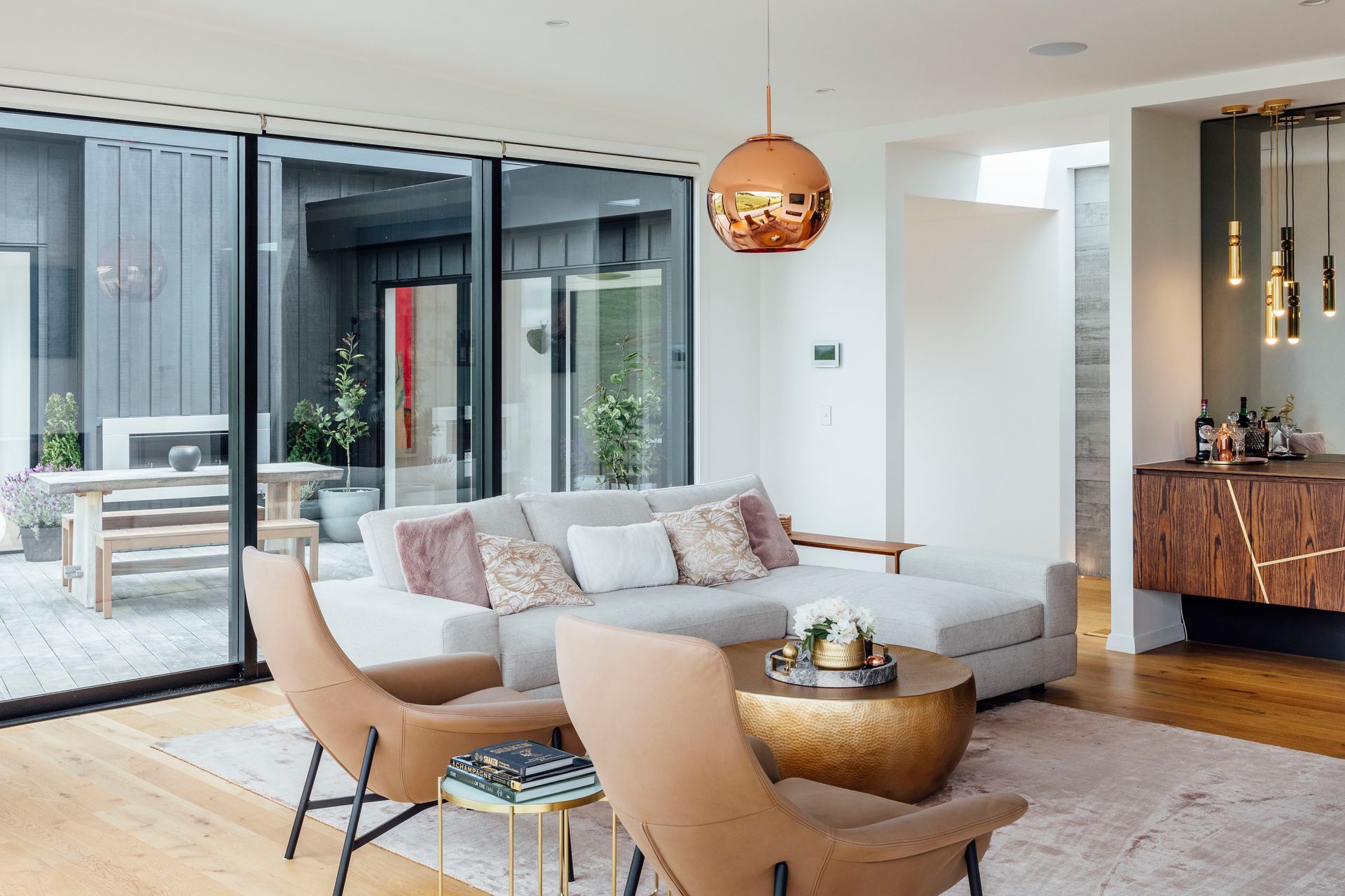 In the living area, Quick-Step compact flooring in 'Natural Oak' has an extra-matt finish. A Valentina rug in 'Blush' from Coco Republic was chosen to define the lounge, where a beaten brass drum coffee table from Freedom teams with Seymour chairs and a J