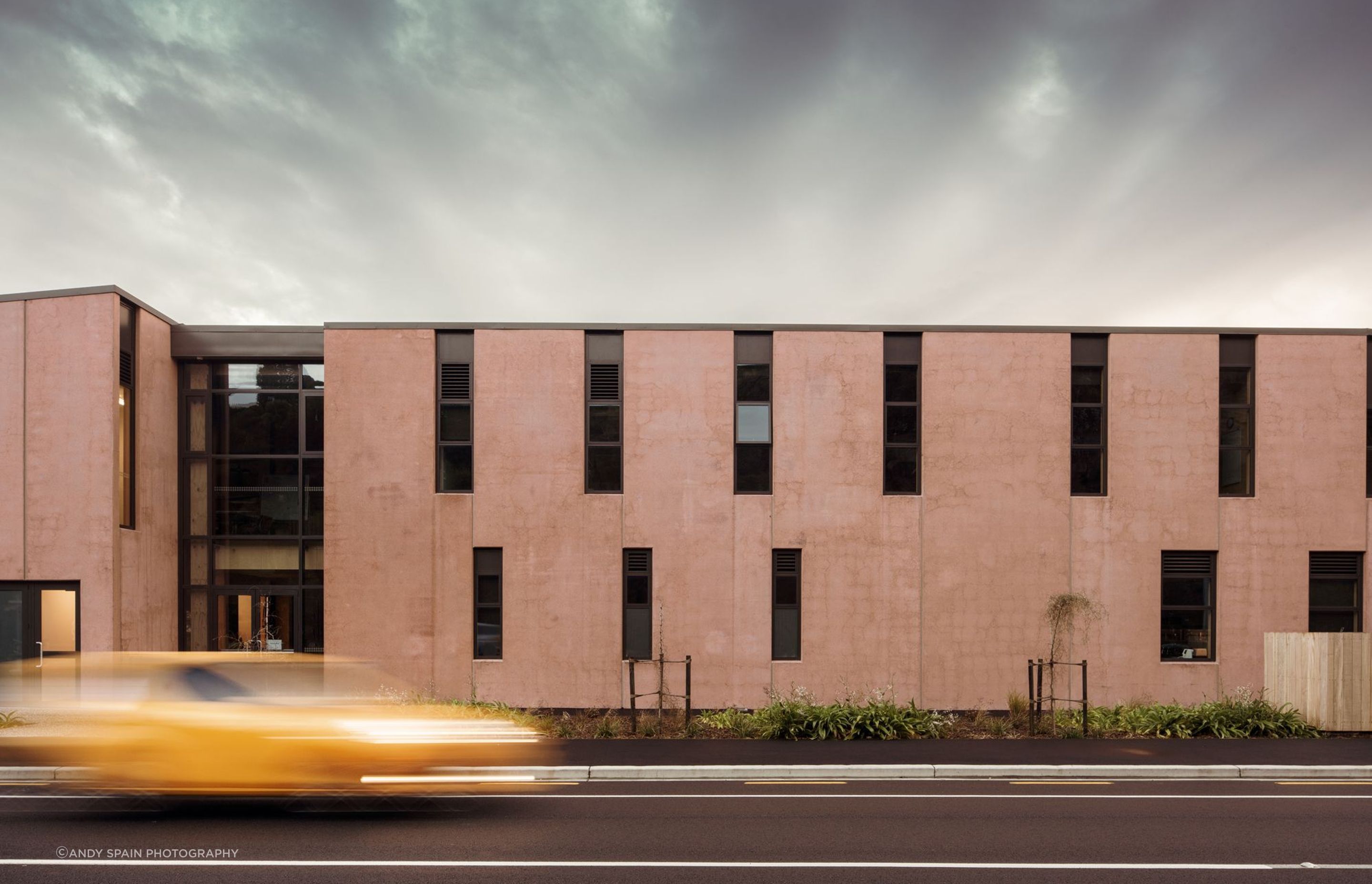 Referencing the cliffs and moa caves across the road, the street-facing facade of the school is a 60 metre-long, 8 metre-high series of modulating openings and setbacks arranged from precast concrete.
