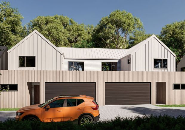 Contemporary multi-unit residential facade with a symmetrical gabled upper level clad in light vertical boards, a recessed central section, and a lower level containing dark double garages and pedestrian doors. A bright orange car is parked in front, with mature trees behind the building.