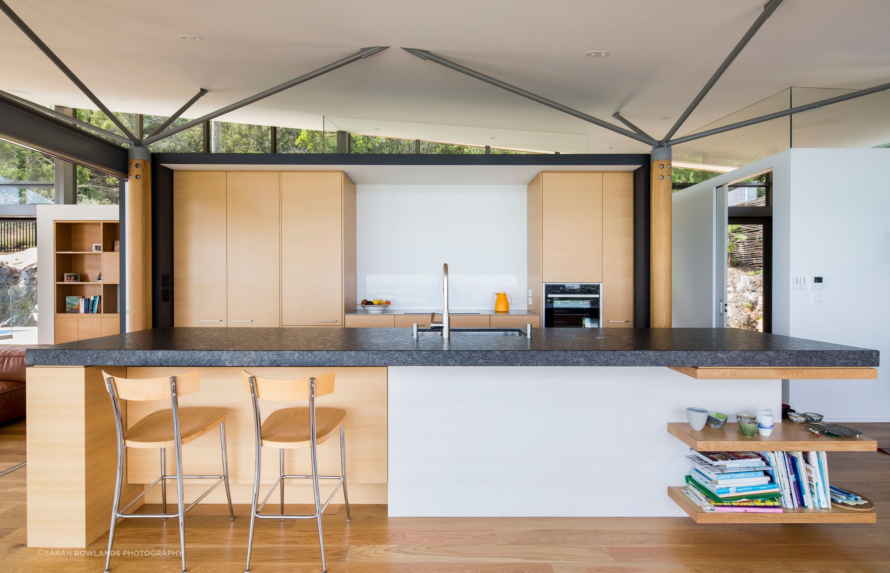 A galley kitchen takes centre stage in the open-plan living area, separating the dining space from the lounge. A WC has been cleverly concealed on the other side of the cabinetry and a small snug can be seen off to the right.