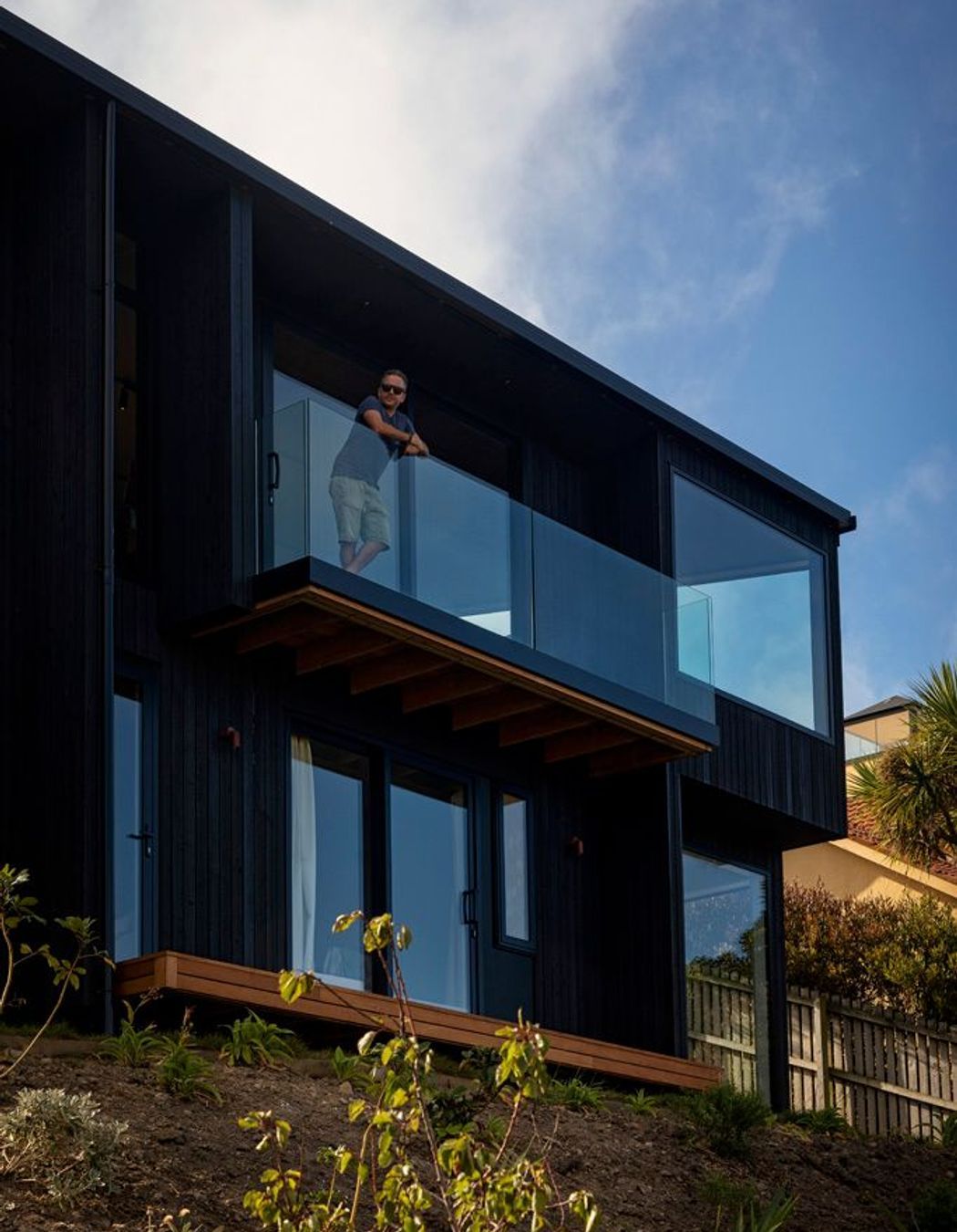 The East-facing facade features large-scale glazing to maximise views out across the bay and adjacent headland.