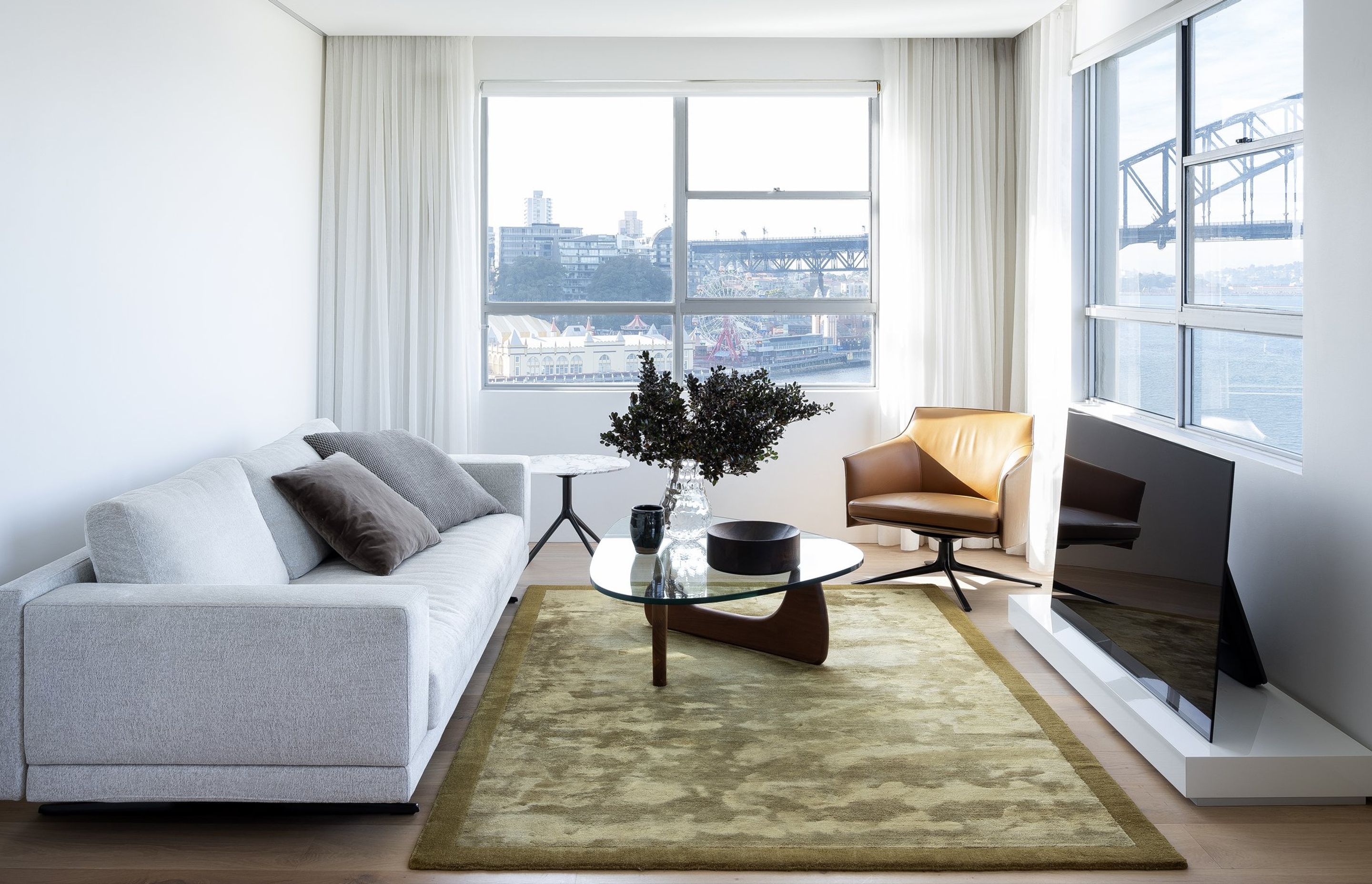 Poliform's Mondrian sofa and Stanford armchair all feature in the McMahons Point apartment along with the Poliform Frame rug in olive green bamboo and silk.