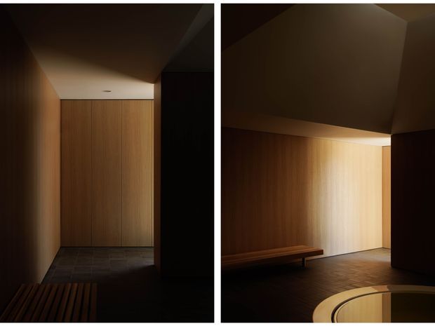 Diptych showing a dark, minimalist interior hallway or entry area with warm vertical timber wall panelling, a dark tiled floor, concealed or flush doors, angular plasterboard ceiling planes, and a simple timber bench. Dramatic directional lighting creates a warm, moody atmosphere.