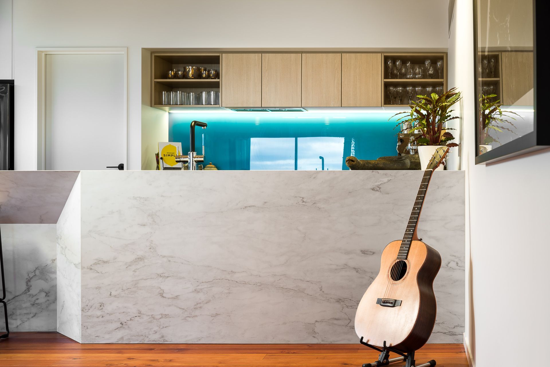 A large, faceted marble island adds further architectural interest to the open-plan living space.